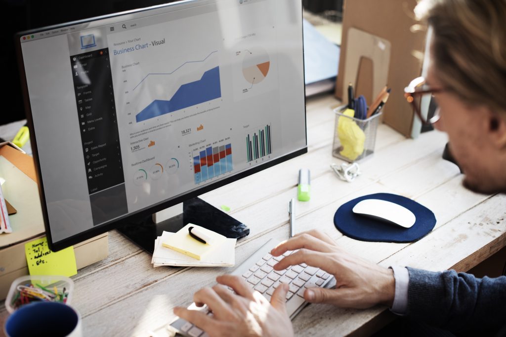 Businessman looking at a computer of analytical charts, similar to how data centre infrastructure management can display analytical information.